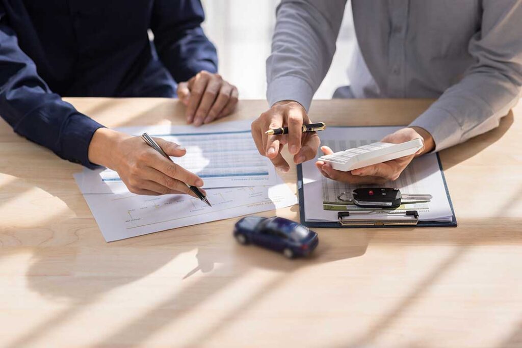 A resident reviews insurance documents at a kitchen table with a notepad and phone.