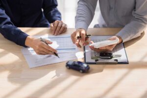 A resident reviews insurance documents at a kitchen table with a notepad and phone.